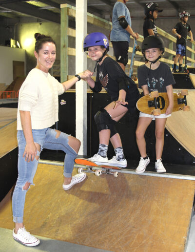 A parent helps out her two young daughters on one of the beginner ramps at Alley Oops Indoor Skatepark. Photo: Richard Bruinsma